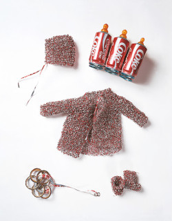 Fiona Hall Medicine Bundles for the non-born child, 1993; aluminium, rubber teats; child's jacket (28 x 44 x 10 cm), child's booties each (8.5 x 9 x 5.2 cm), child's bonnet (13 x 13 x 7 cm), child's teething ring (31 x 9 cm) diameter; Enquire