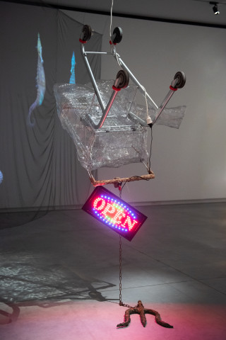Mikala Dwyer Hotel Seahorse, 2023; shopping trolley, bronze, chain, plastic, caulk, marine pebbles, electric sign; enquire