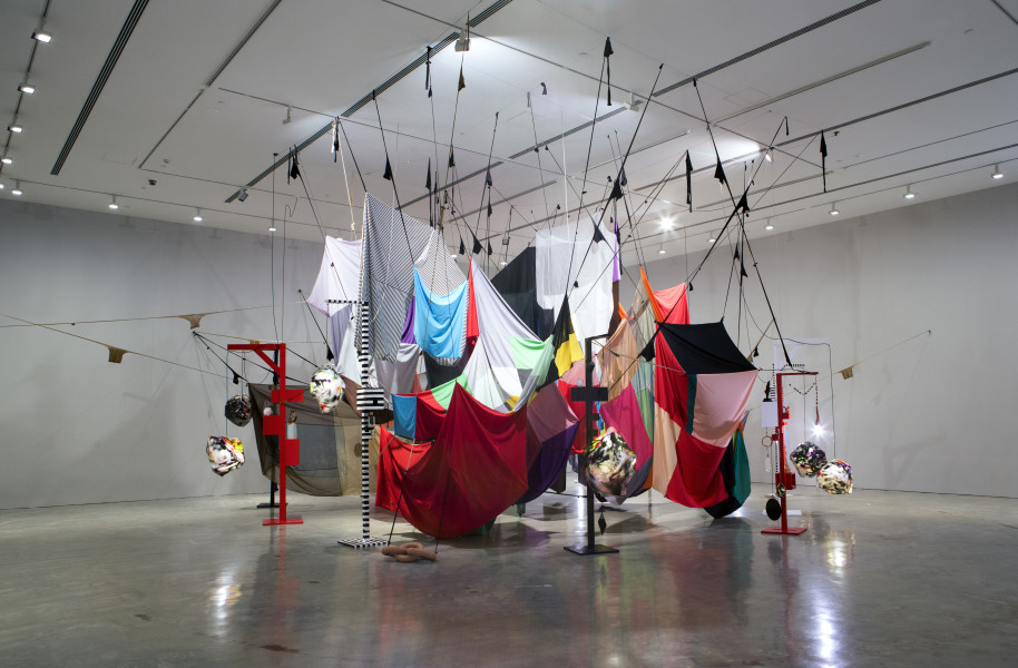 Installation view; Mikala Dwyer Square Cloud Compound, 2010; fabric, stockings, pins, glass bottles, rocks, lights and lamps; Dimensions variable. Adjustable height; enquire